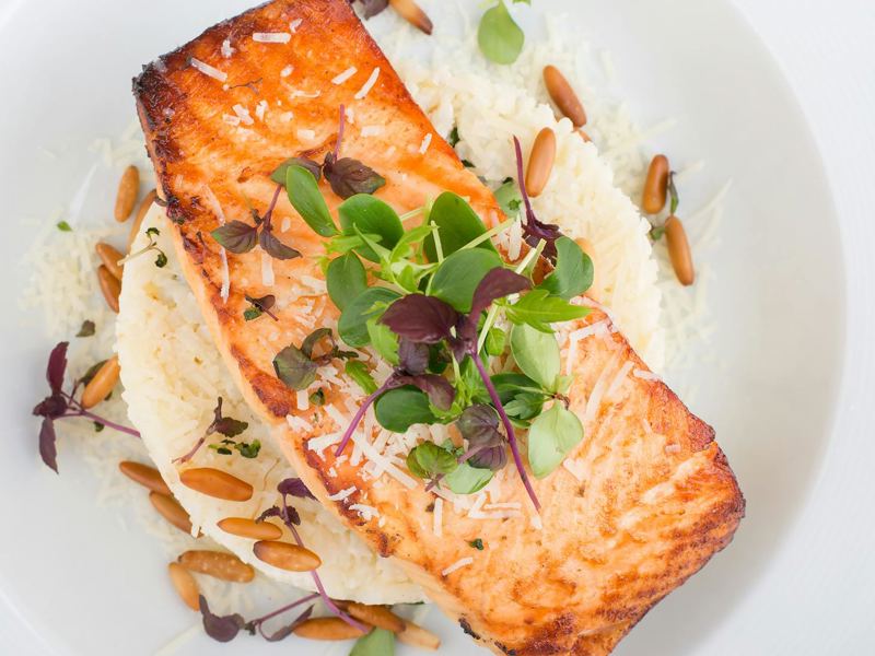 delicious grilled salmon served with rice, pine nuts, and microgreens image