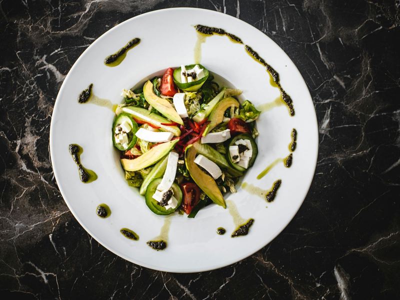 delicious overhead shot of fresh avocado salad with feta cheese on a m image